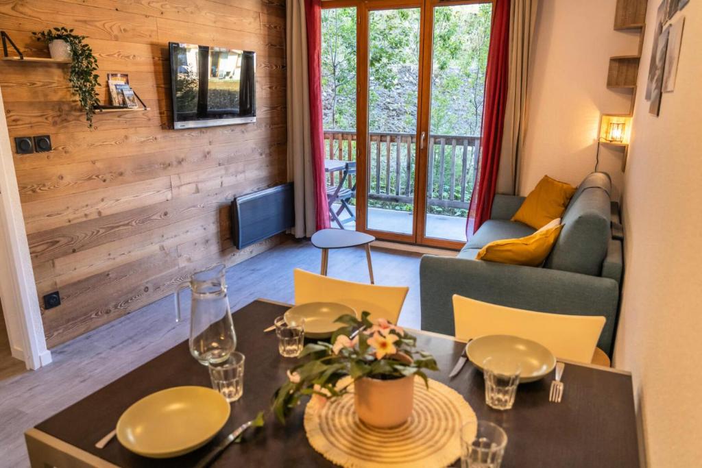 un salon avec une table et un canapé dans l'établissement Résidence Les Terrasses Du Soleil D'or - Appartement 2 pièces joliment rénové MAE-4314, aux Orres