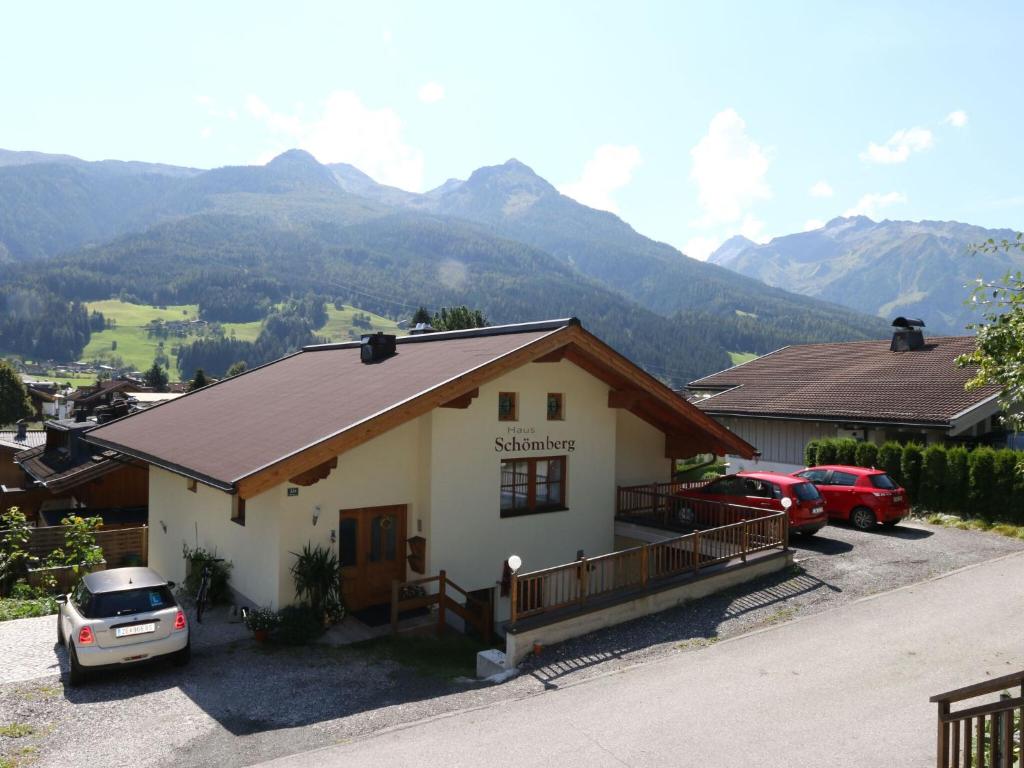 a house with cars parked in front of it with mountains at Apartment in Bramberg am Wildkogel with parking space in Bramberg am Wildkogel