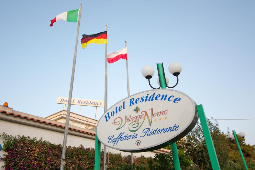 a sign in front of a building with three flags at Hotel Residence Nemo in Brindisi