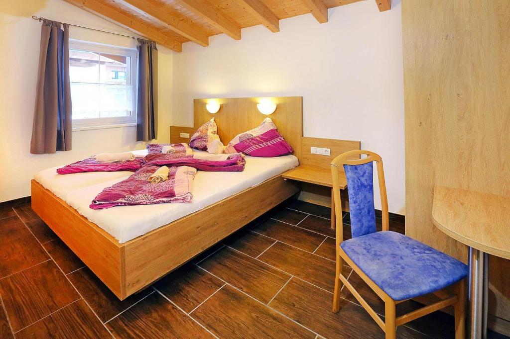 een slaapkamer met een bed, een bureau en een stoel bij Terraced Houses Oliver L ngenfeld in Längenfeld