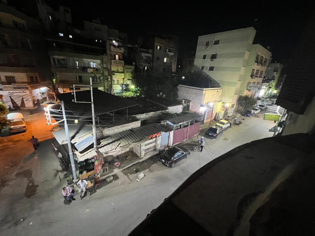 una vista aérea de una calle de la ciudad por la noche en غرفه واحده فقط داخل شقه بها سرير ١٢٠ سم ومروحه ودولاب وكراسي en El Mansurá
