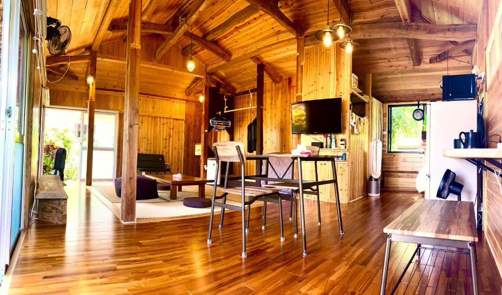 a living room with a table and chairs in a cabin at 一棟貸しの移住案内古民家　itoma in Setouchi