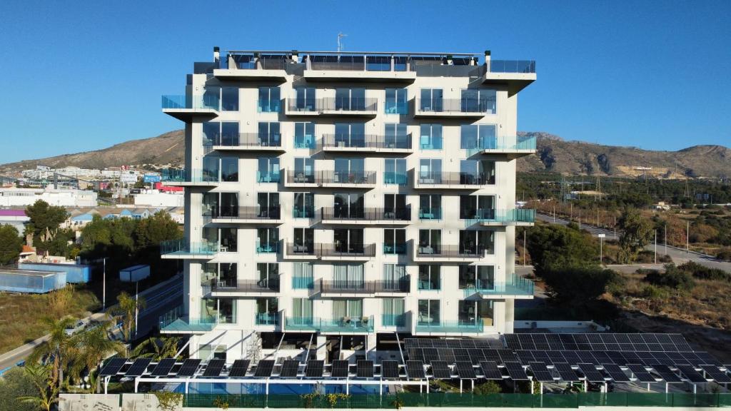 un edificio con paneles solares delante de él en APARTAMENTOS OASIS DE LA CALA, en Finestrat