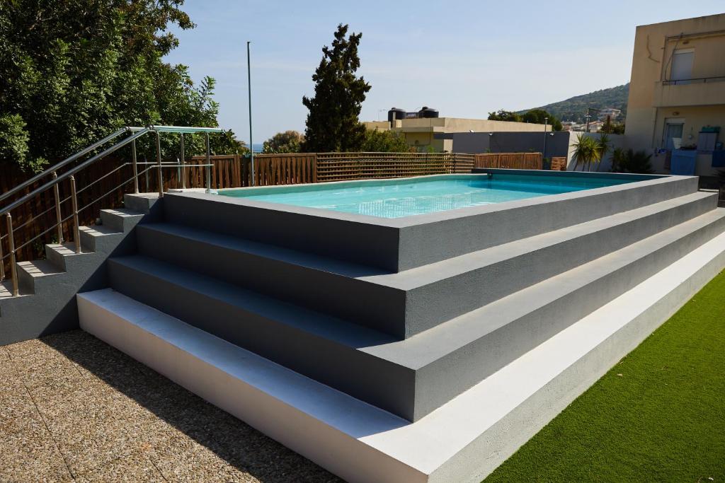 a swimming pool with concrete steps and a swimming poolvisor at Nur Villa in Karfas