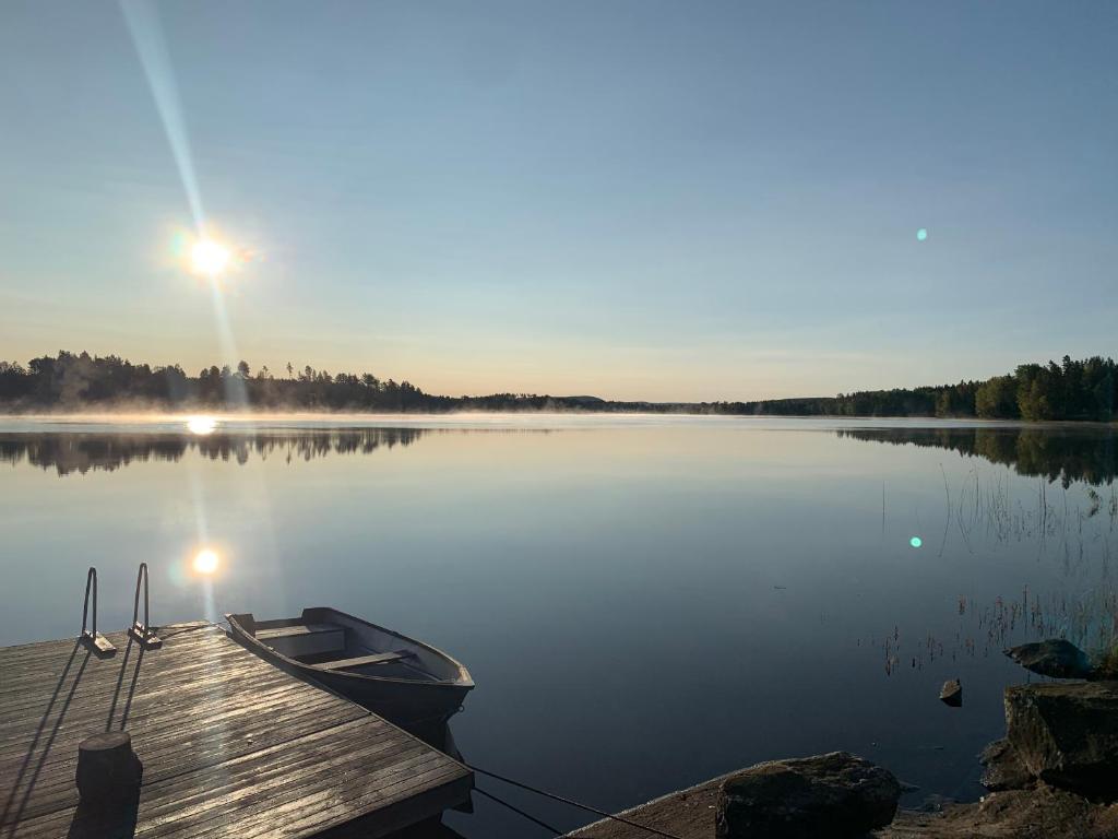 Ein Boot liegt an einem Dock auf einem See. in der Unterkunft Cozy cottage by the lake, Charlottenberg in Åmotsfors
