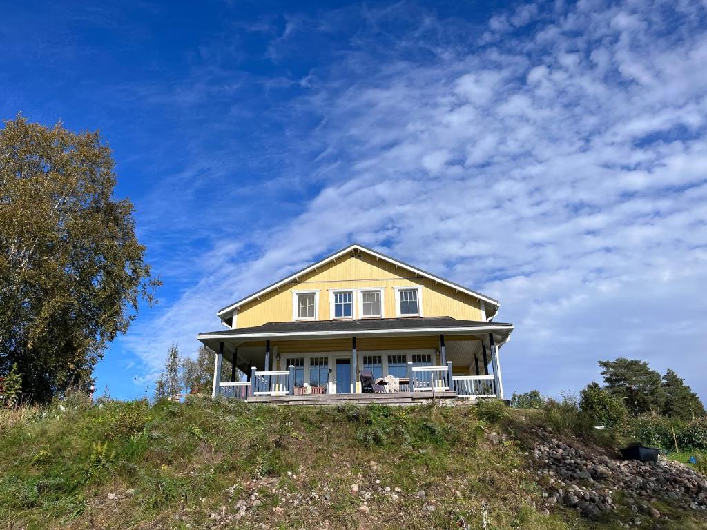een geel huis bovenop een heuvel bij Ferienhaus Anders in Terjärv