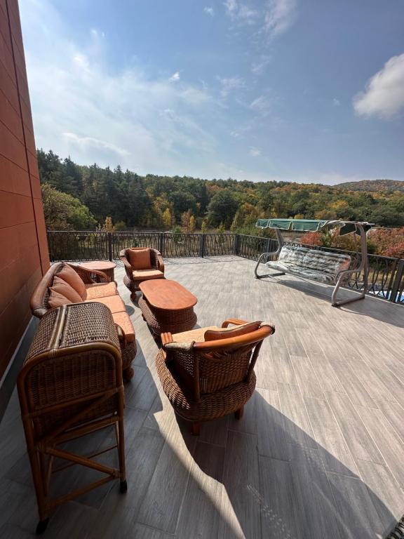 un patio con sillas y mesas en una terraza en Alvina apartment hotel, en Tsaghkadzor