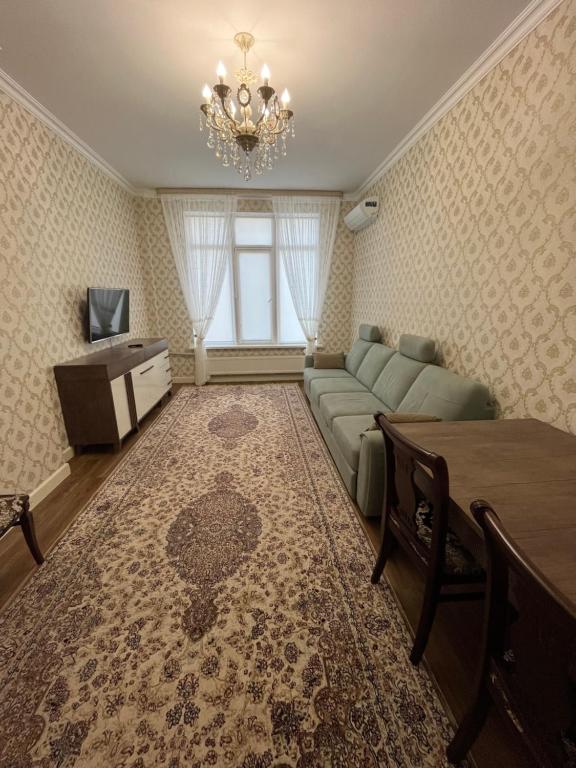 ein Wohnzimmer mit einem Sofa und einem TV in der Unterkunft 2-х комнатная квартира в ЖК Заман in Atyrau