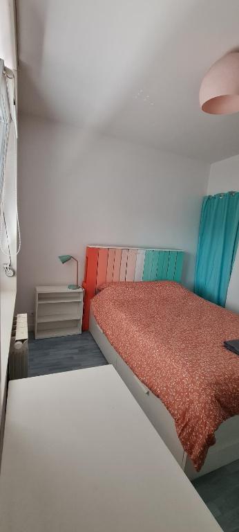 een kleine slaapkamer met een bed met een rode deken bij La brique rouge - Maison 66 m2 avec 2 chambres in Lille