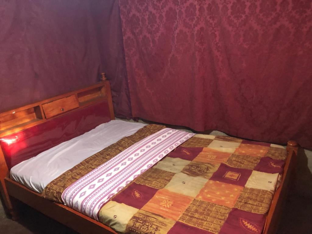 a bedroom with a bed with a quilt on it at Kiharas Farm stay in Nairobi