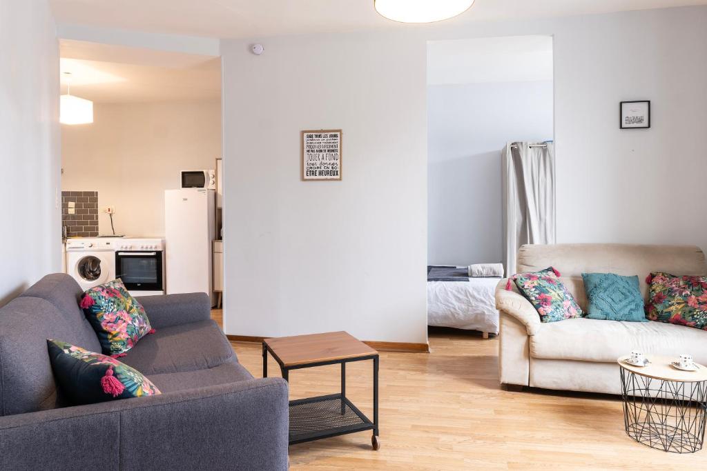 ein Wohnzimmer mit einem Sofa und einem Tisch in der Unterkunft grand studio ✰ 35m² ✰ centre ✰ 4pers/2lits ✰ cuisine ✰ wifi in Candé