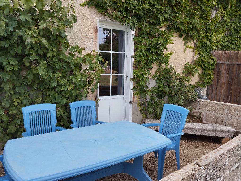 a blue table and chairs in front of a building at Maison au calme avec vue étang in Clessé