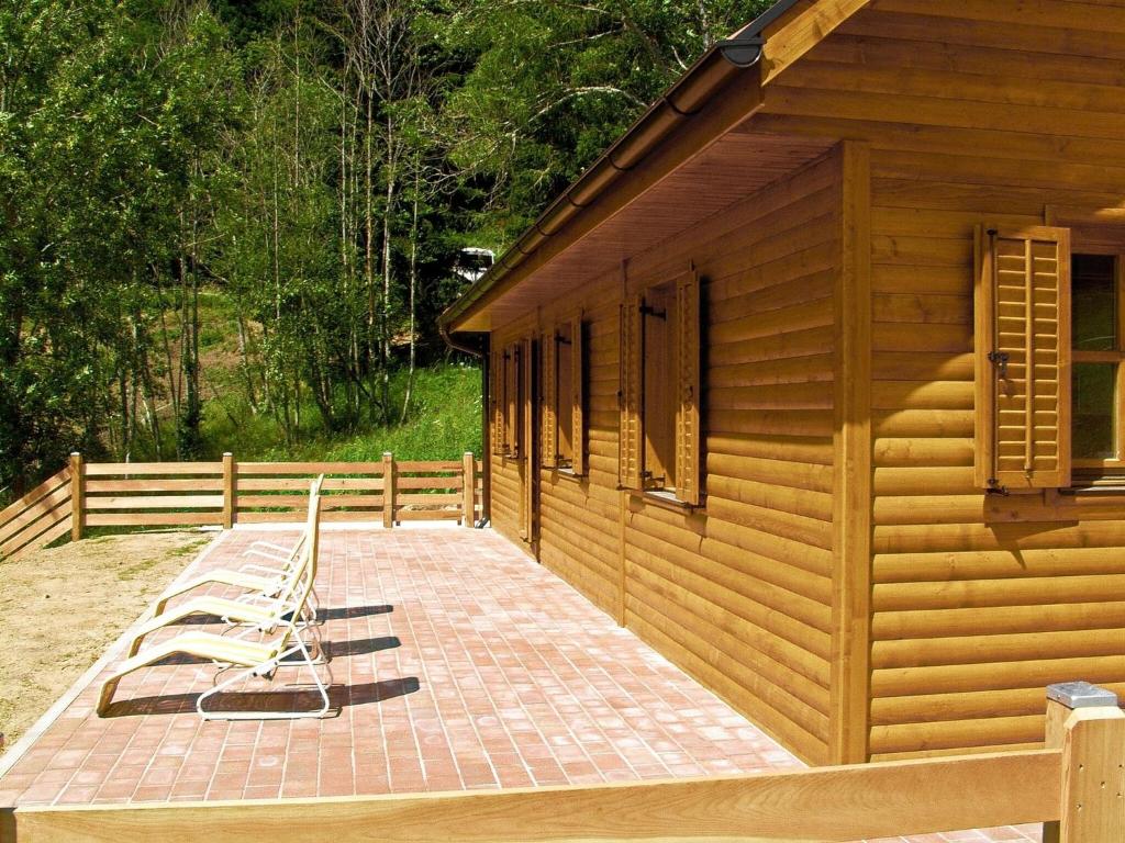 a large deck next to a wooden building at Detached wooden chalet in Liebenfels Carinthia near the Simonh he ski area in Liebenfels