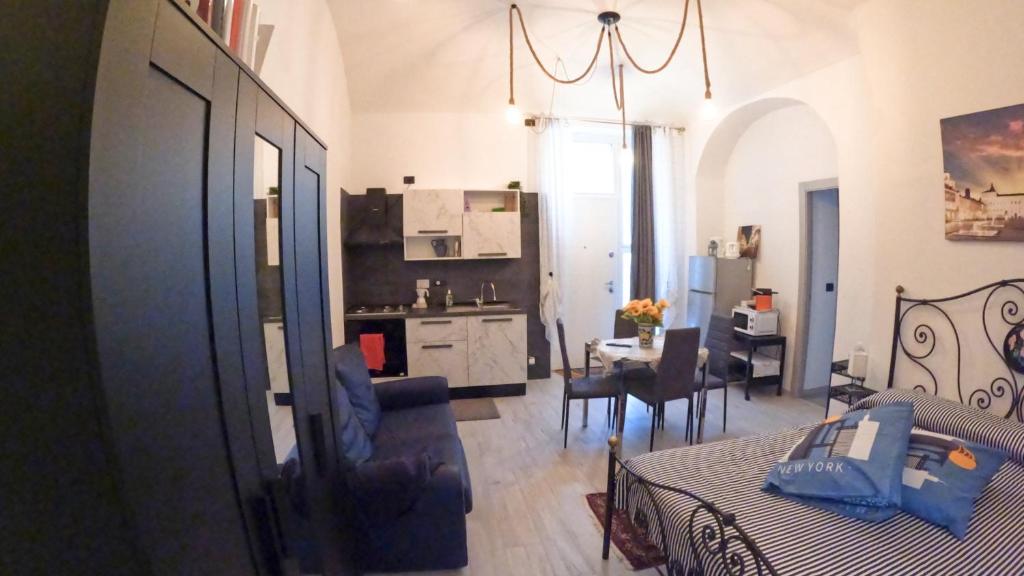 a bedroom with a bed and a kitchen with a table at Musinè House in Turin