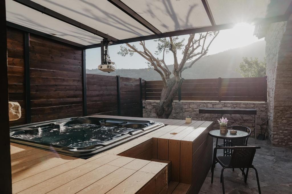利馬索爾的住宿－The Stonehouse Suites，一个带桌子和树的房间的热水浴缸