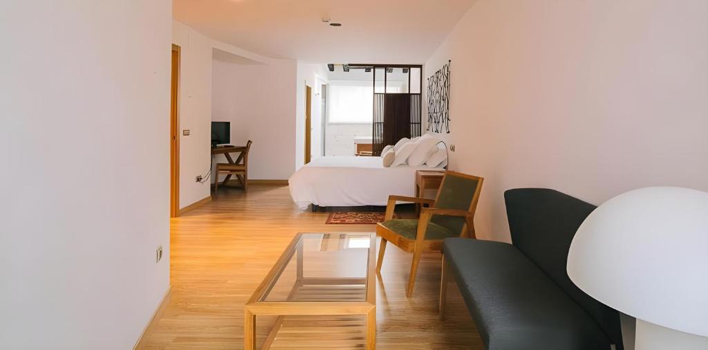 een slaapkamer met een bed en een tafel in een kamer bij Hotel Rural Quercus Tierra in Garganta de los Montes