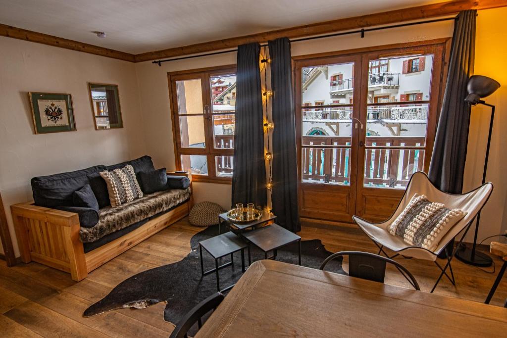 a living room with a couch and a table at Arc 1950 Appartement skis aux pieds in Arc 1950