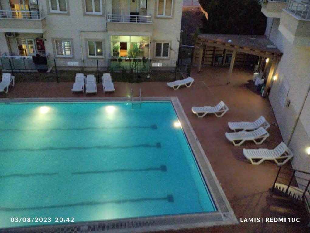 una piscina vacía con sillas y un edificio en شقة مفروشة مطلة ع مسبح, en Bursa
