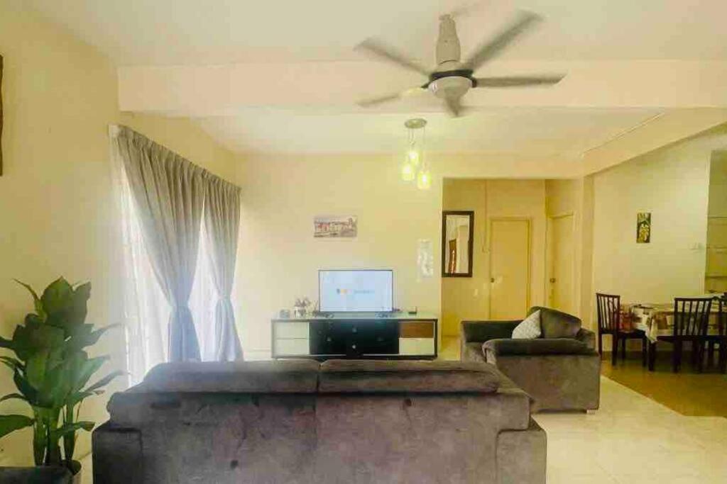 uma sala de estar com um sofá e uma ventoinha de tecto em Landed 3BR near Bangi Wonderland - Wi-Fi, Netflix em Kajang