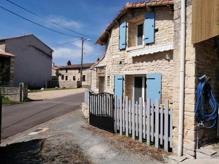 una cerca blanca frente a una casa en Gîte Bin Benaise linge compris, en Pamproux