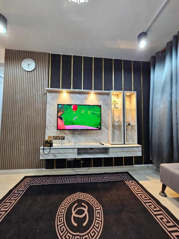 a living room with a television on a wall at Dieyra Homestay in Kuala Terengganu
