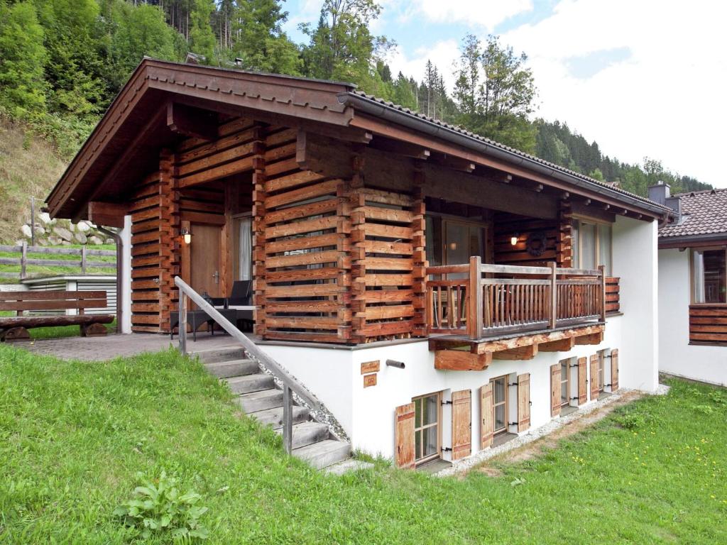 a log cabin with a staircase and a balcony at Luxurious chalet with sauna in K nigsleiten in Wald im Pinzgau