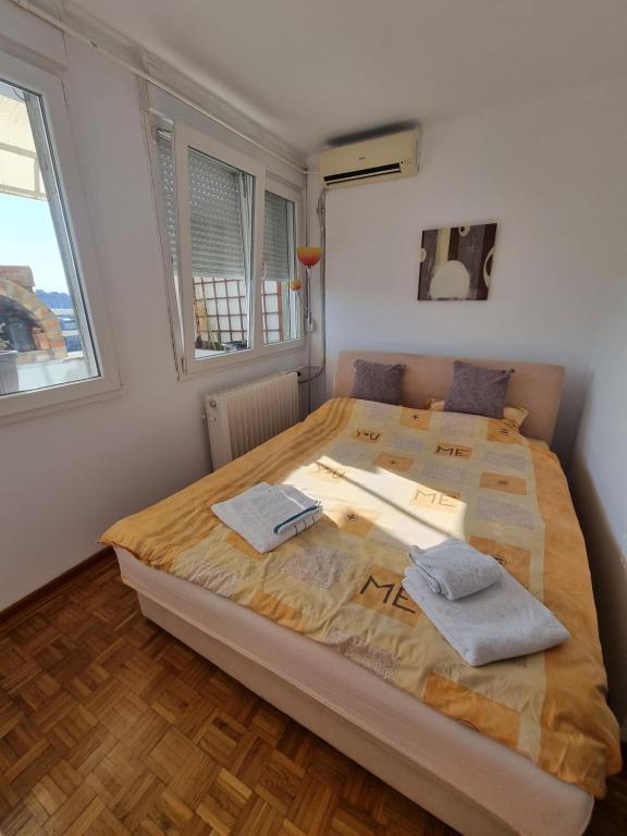 a bedroom with a large bed with two towels on it at Ušće apartman in Novi Beograd