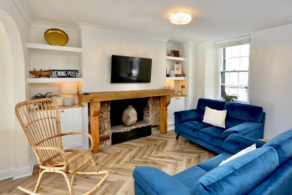 a living room with a blue couch and a fireplace at Cwm Seren - Luxury Apartment in Crickhowell