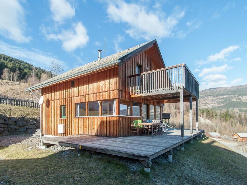 a large wooden house with a deck on a hill at Cosy Chalet in Stadl an der Mur with Valley Views in Stadl an der Mur