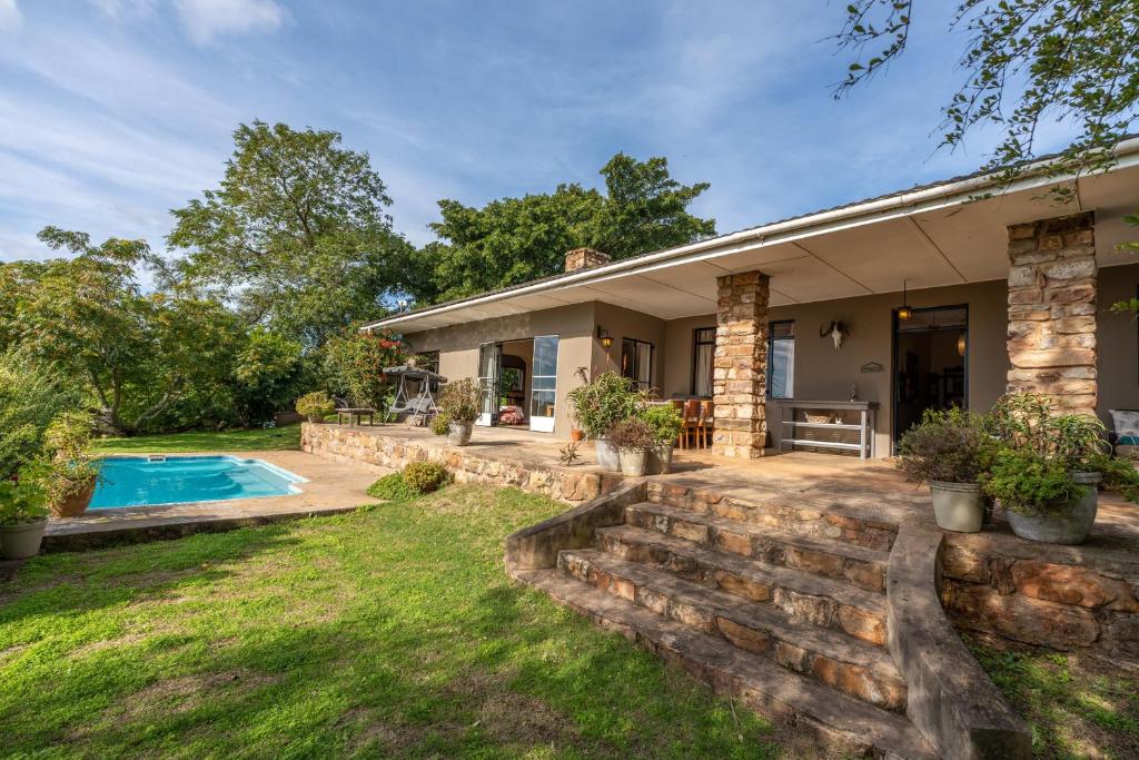 una casa con piscina y patio en Tygerfontein Safari Villa, en Reserva de Amakhala