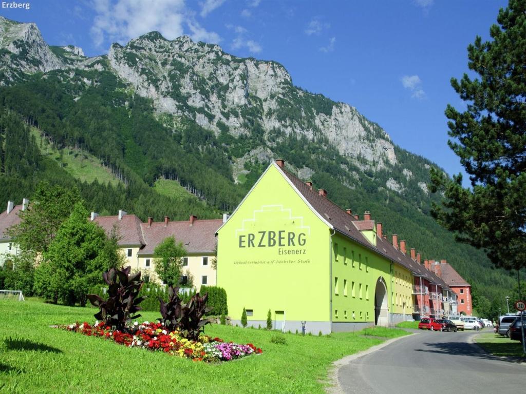 a yellow building in front of a mountain at Hilltop Apartment in Eisenerz with Garden in Eisenerz