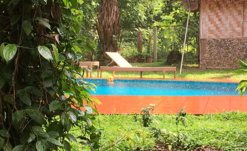 a swimming pool with a bench in a yard at Sang Tong Huts in Mae Hong Son