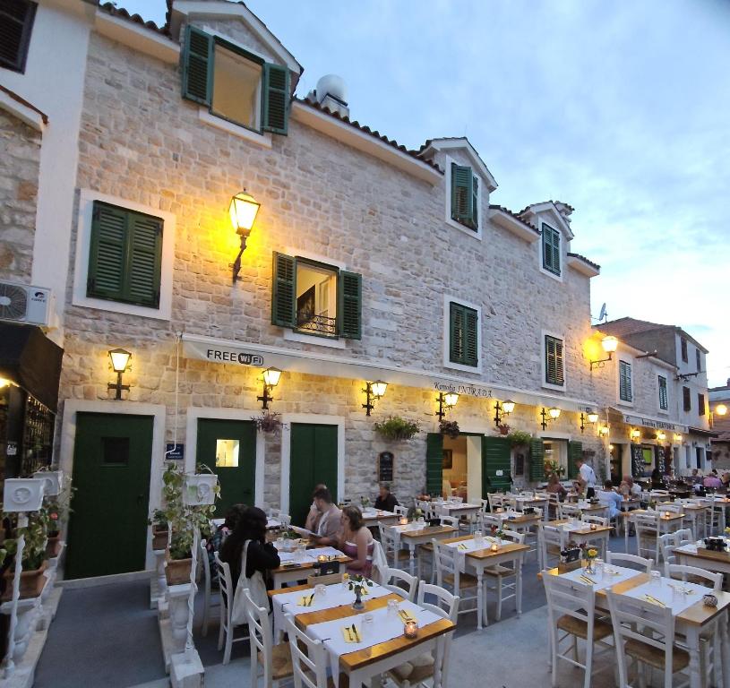 people sitting at tables in front of a building at Centar Vodice Apartmani in Vodice