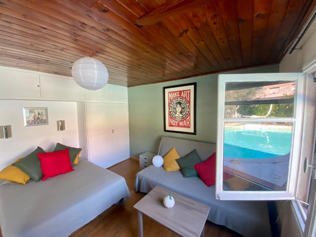 - un salon avec deux lits et une fenêtre dans l'établissement Maisonette proche VÉLODROME, à Marseille