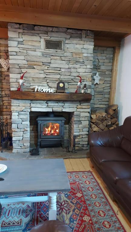 a stone fireplace in a living room with a couch at Rogla - Koča Mojca Pokrajculja in Zreče