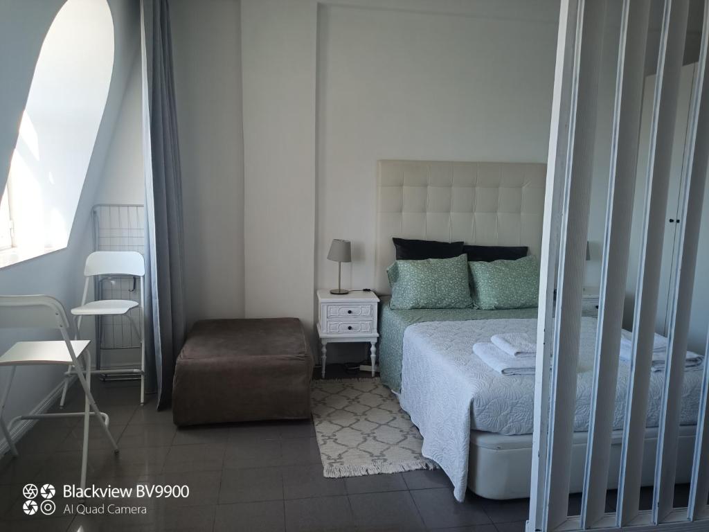 a bedroom with a bed and a chair at Oporto apartment Batalha in Porto