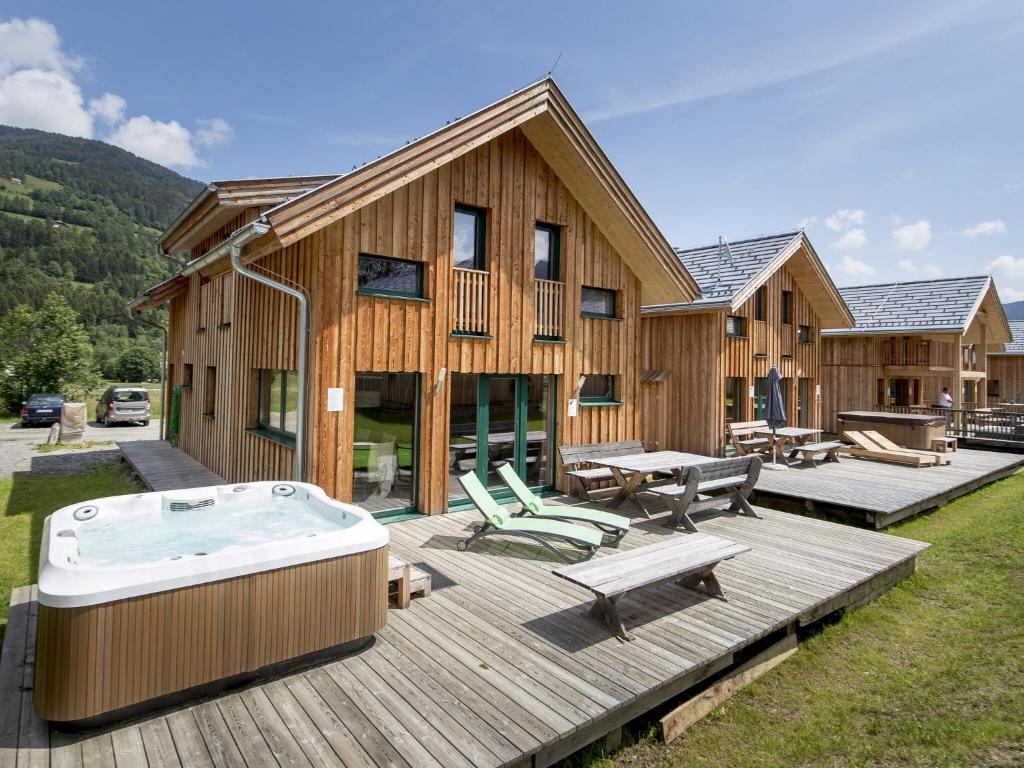 a large wooden house with a hot tub on a deck at Wooden Chalet in Sankt Georgen ob Murau with Sauna in Sankt Lorenzen ob Murau