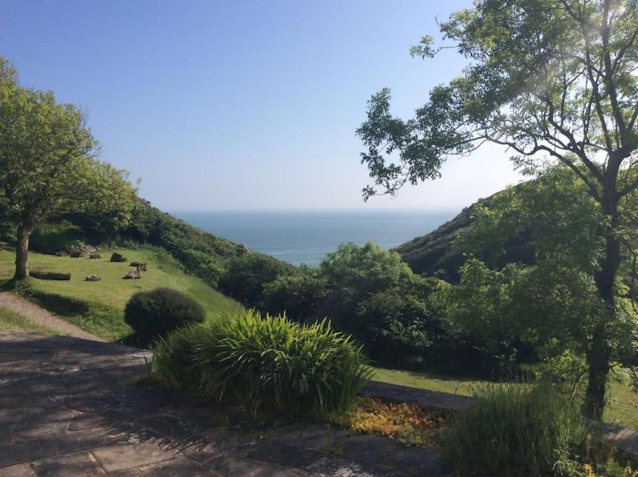 a view of a hill with the ocean in the background at West Winds in Oxwich