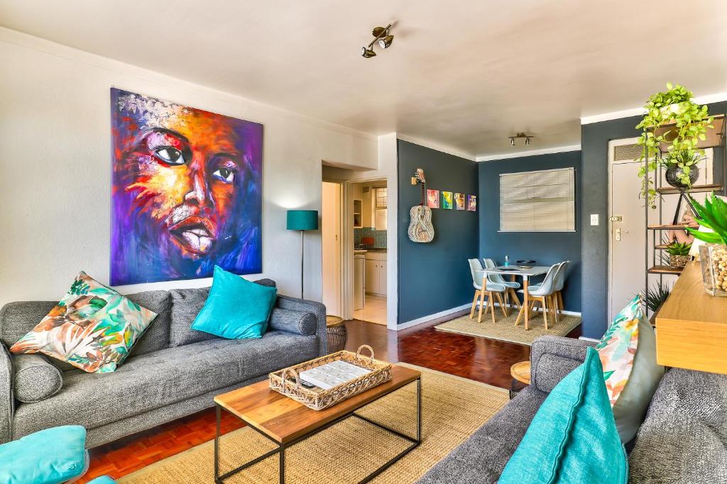 a living room with a couch and a painting on the wall at Trendy 1 bedroom flat in the heart of Green Point in Cape Town