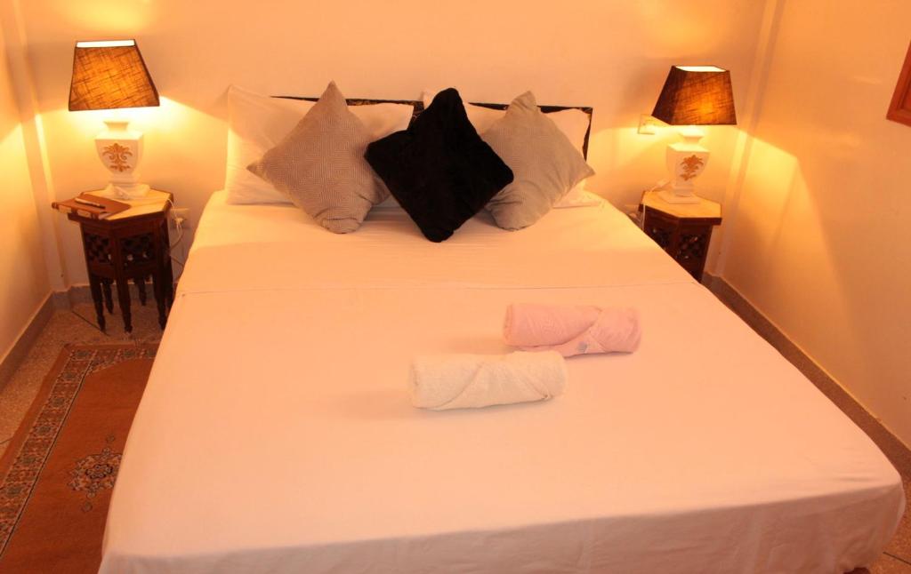 a bedroom with a white bed with two towels on it at Asunfou : Appartement d'apaisement in Mirleft
