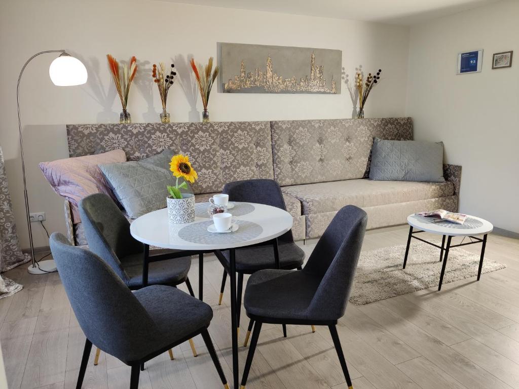 salon ze stołem, krzesłami i kanapą w obiekcie Apartment Dalyce w Szawlach