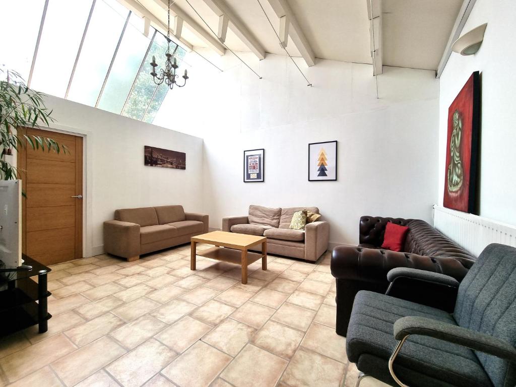 a living room with couches and a table at Heritage House Apartments in Swindon