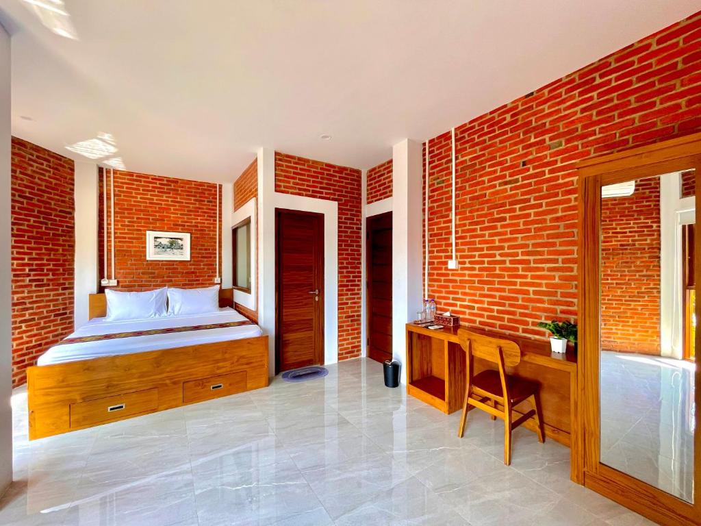 a bedroom with a bed and a brick wall at Puu Pau Hotel & Coffee Shop in Labuan Bajo