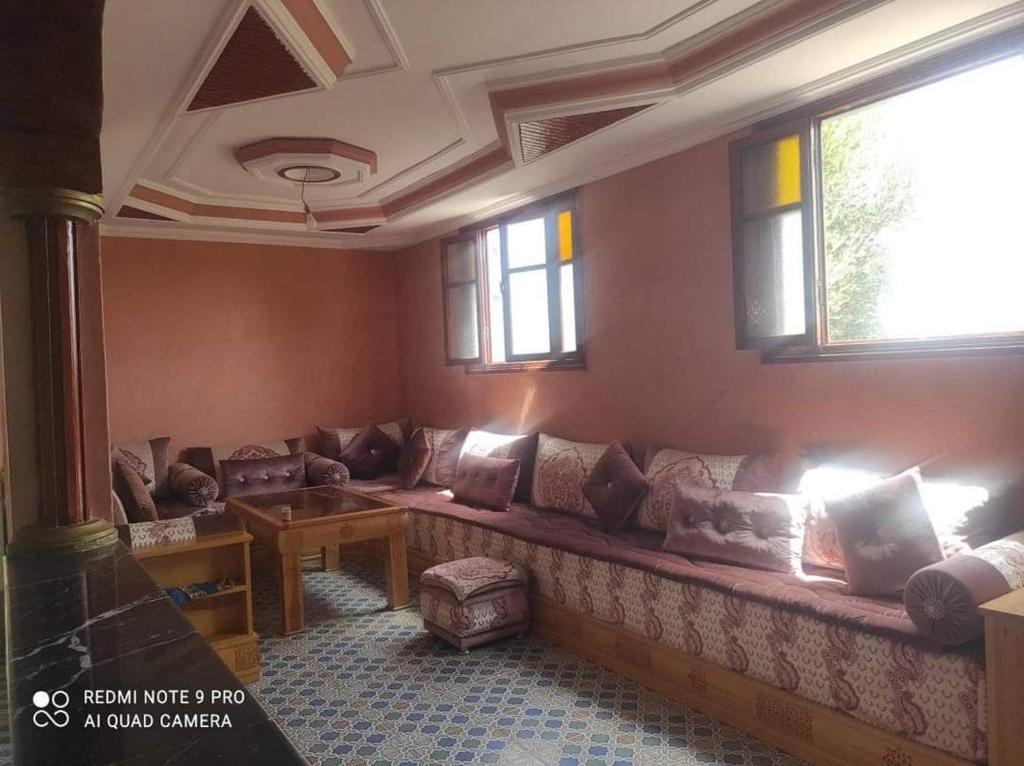 ein Wohnzimmer mit einem großen Sofa und Fenstern in der Unterkunft Villa avec piscine in Essaouira