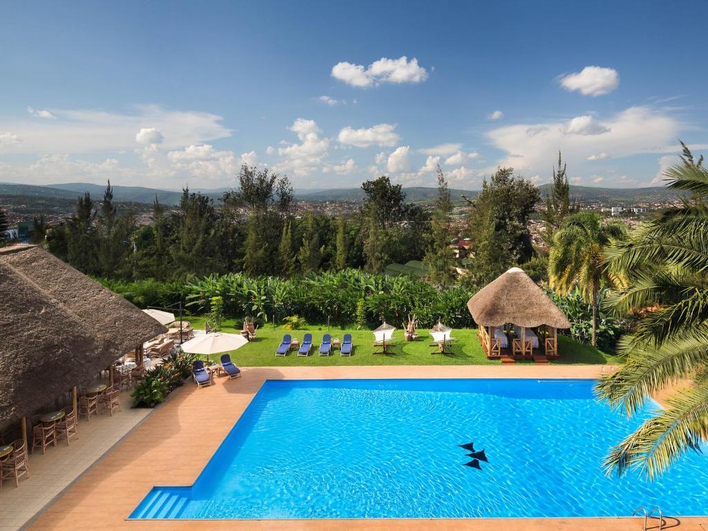 a large swimming pool with a blue sky at Hotel des Mille Collines in Kigali