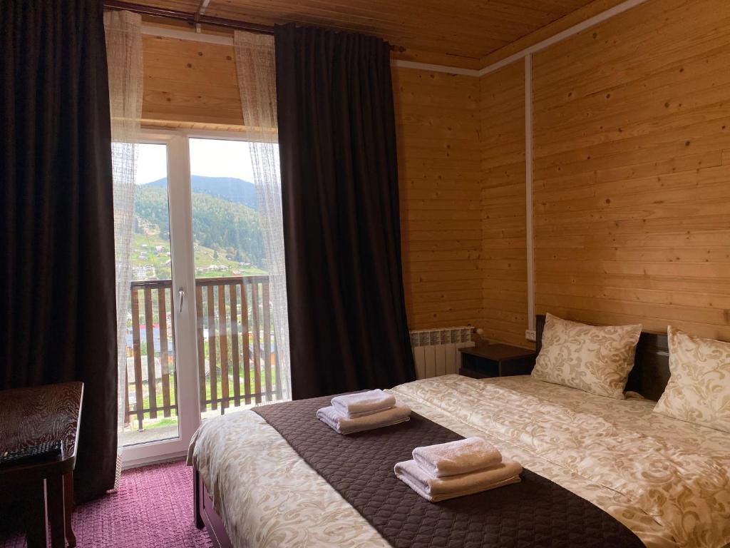 um quarto com uma cama e uma grande janela em FORREST hotel em Bukovel