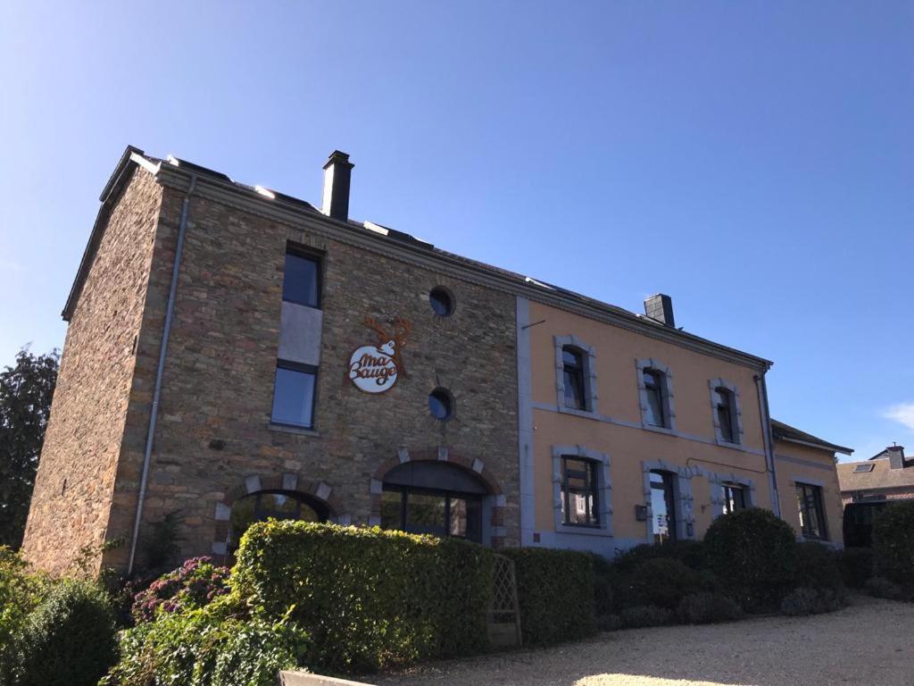 a brick building with a sign on the side of it at Ma Bauge in Libin