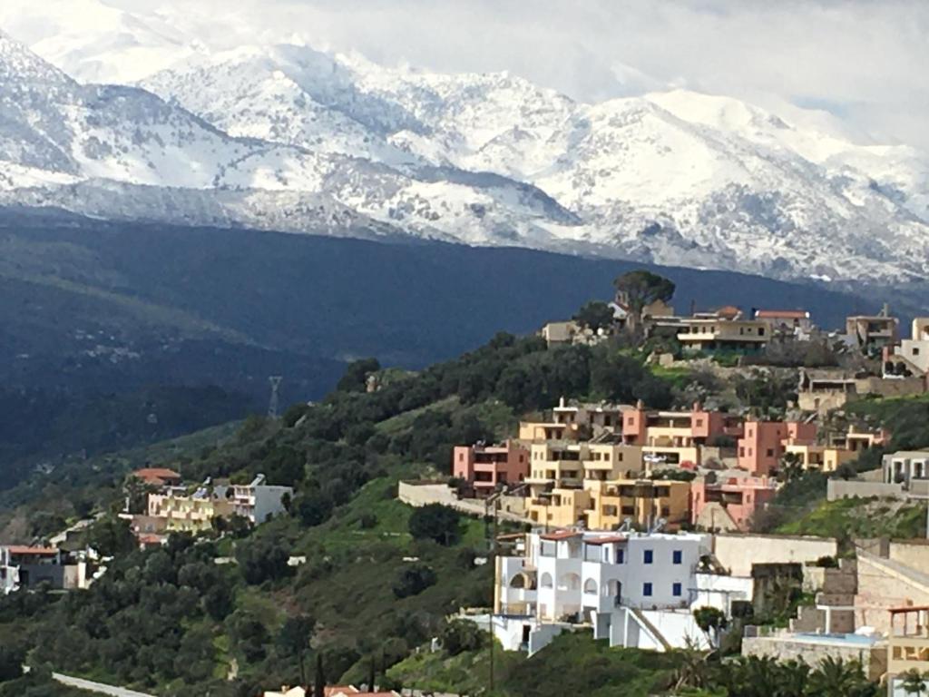 una ciudad en una colina con montañas cubiertas de nieve en Marjoram - Morfi Village, en Exopoli