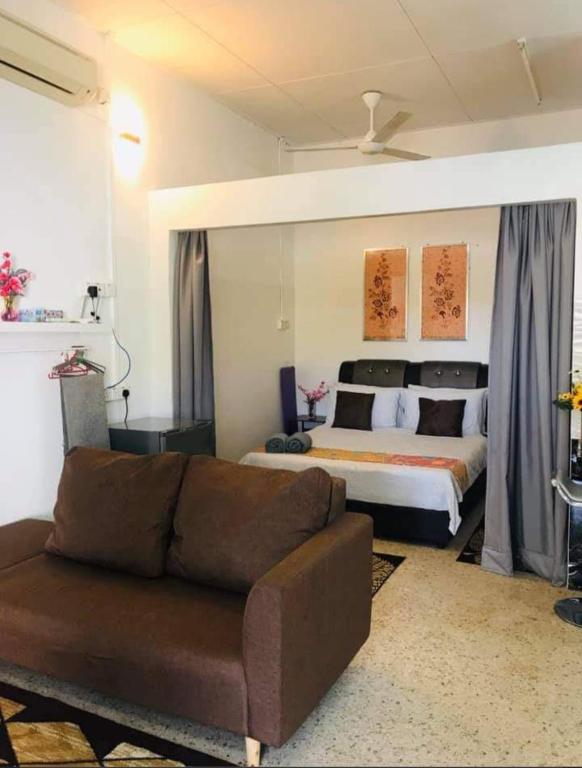 a living room with a couch and a bed at Canal Studio Room Kota Bharu in Kota Bharu