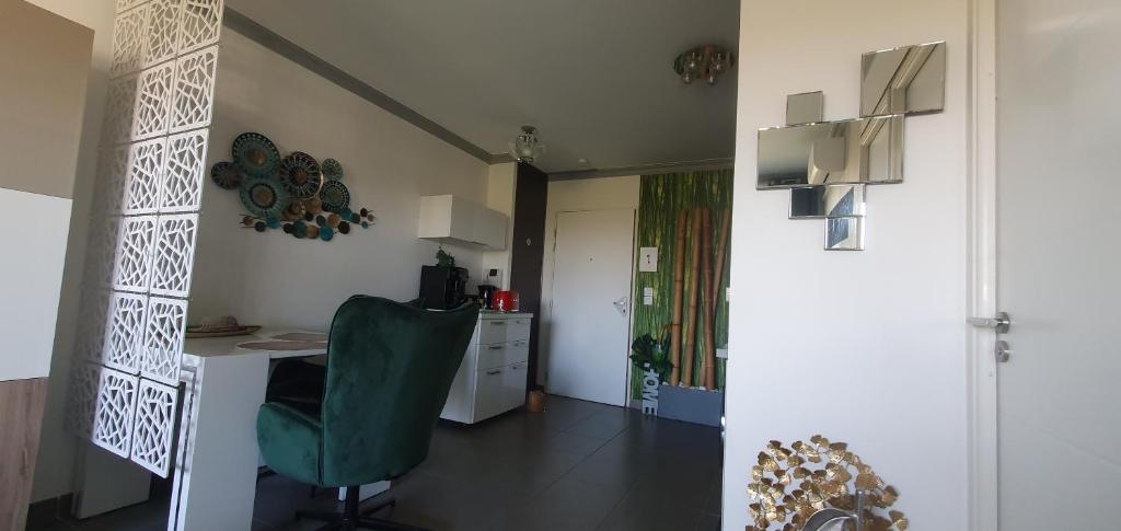 a room with a desk and a green chair at Appartement de L'Espiguette in Le Grau-du-Roi
